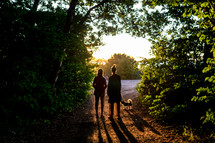 two friends walking their dog in the evening 
