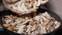 Putting Chopped Mushrooms Into Frying Pan - Close Up