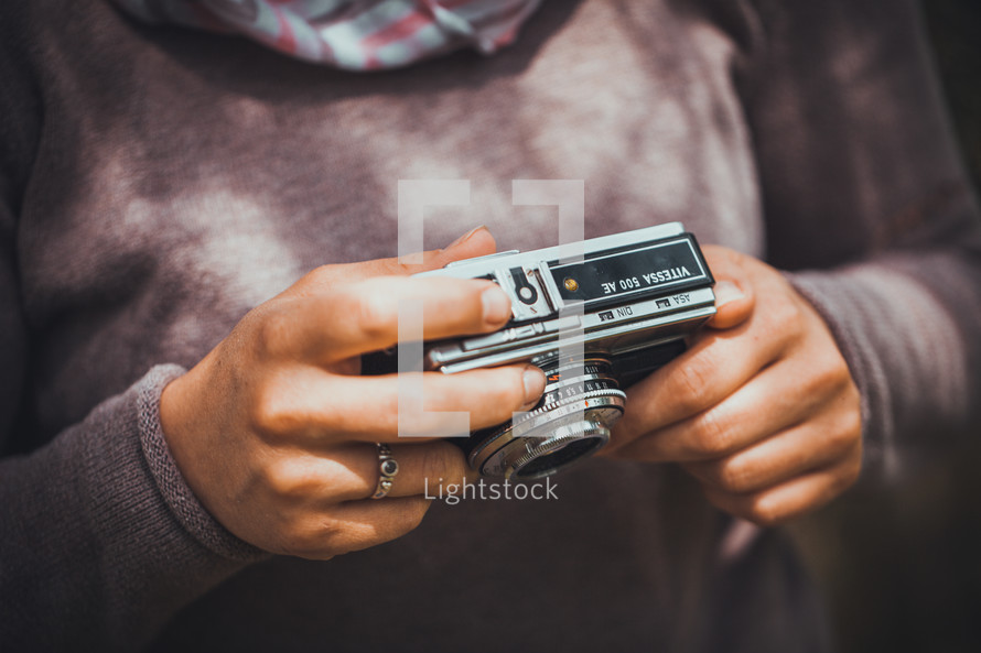 a woman holding a vintage camera 
