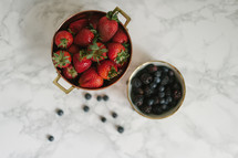 Bowls of berries on a white surface.