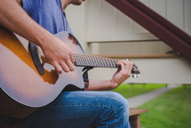 man playing a guitar outdoors 