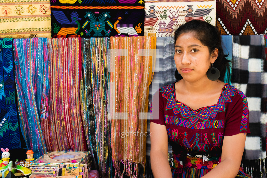 a woman selling blankets in a market 