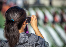 a woman with a camera in the audience at graduation 