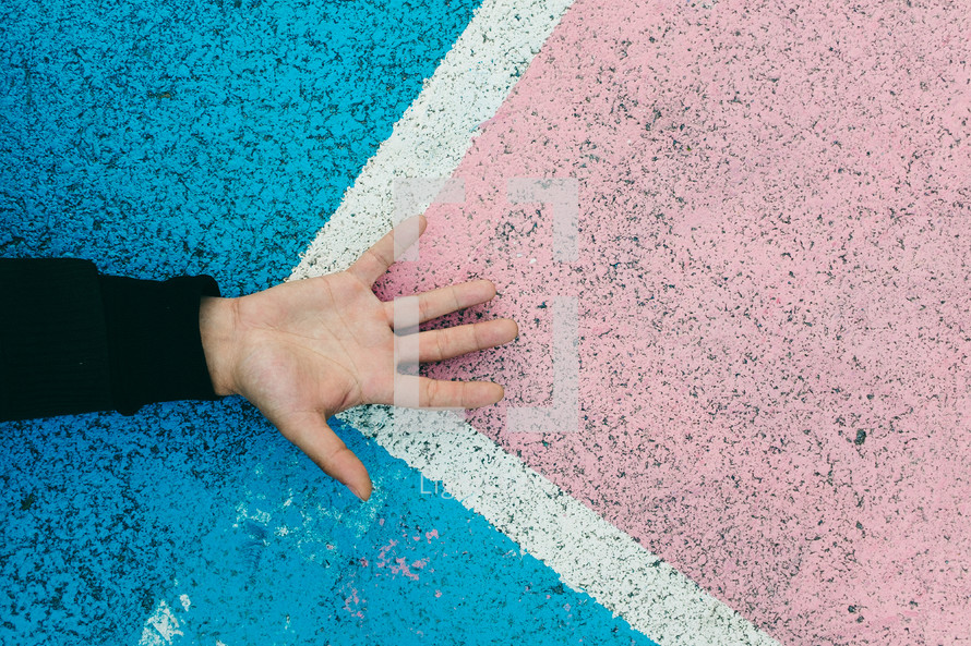 hand on colored pavement 