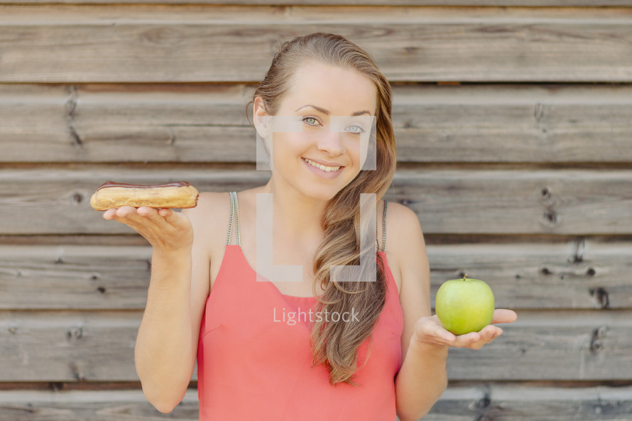 a woman holding sweets and an apple 