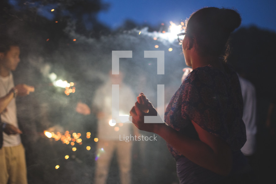 teens around smoke and fireworks at night 