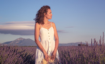 a woman standing in a field of lavender 