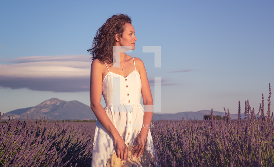 a woman standing in a field of lavender 