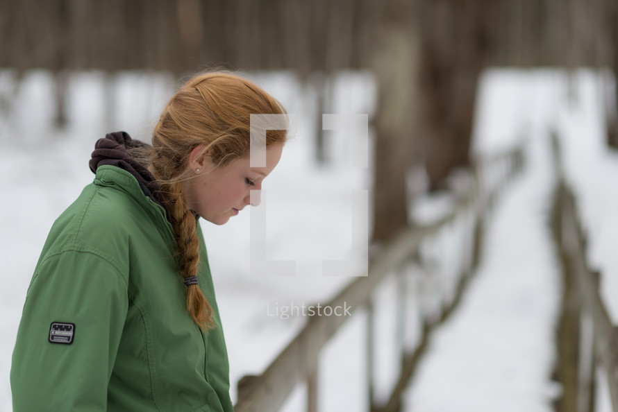 a teen girl standing outdoors in a winter coat 