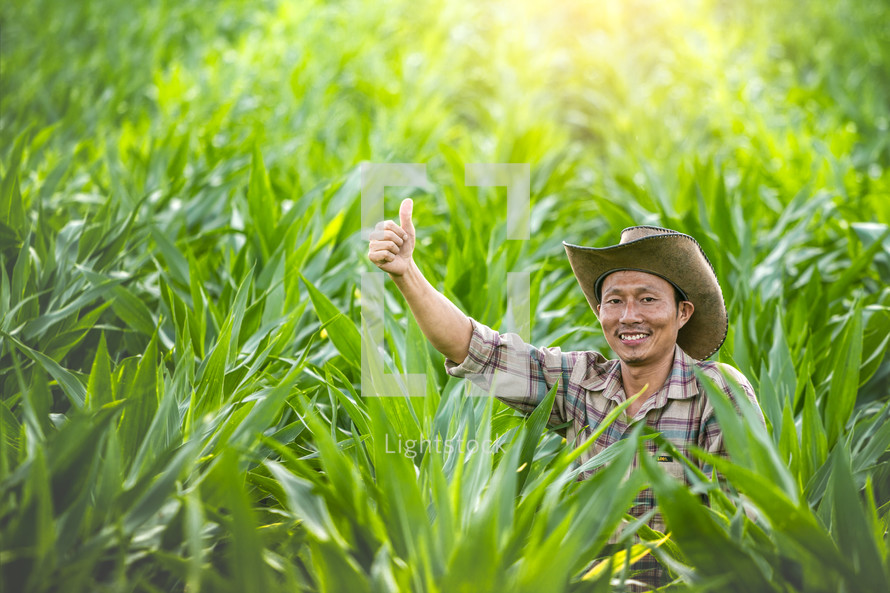 a farmer in a corn field giving a thumbs up 