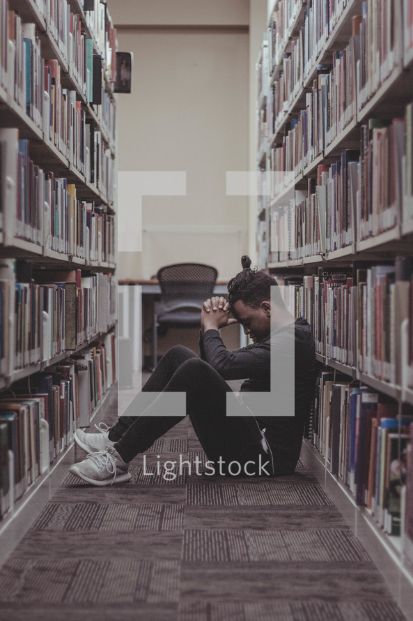 a man praying in a Library 
