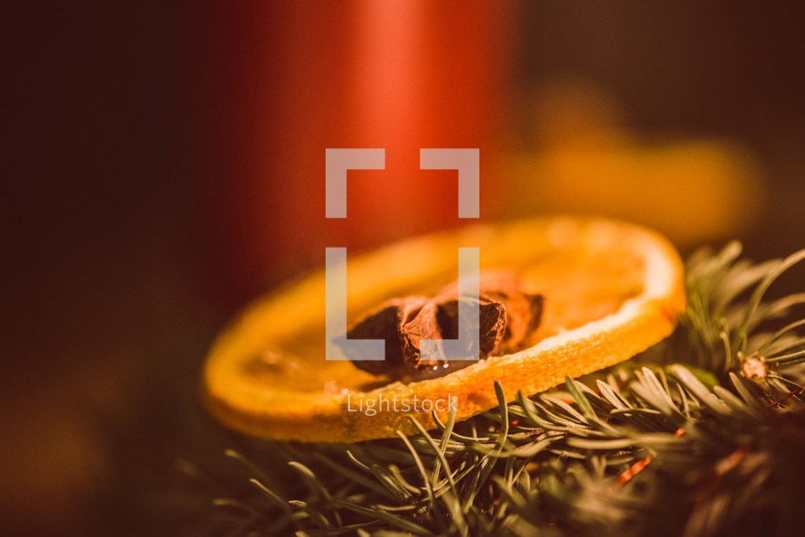 orange, cloves, greenery, and a candle Christmas scents 