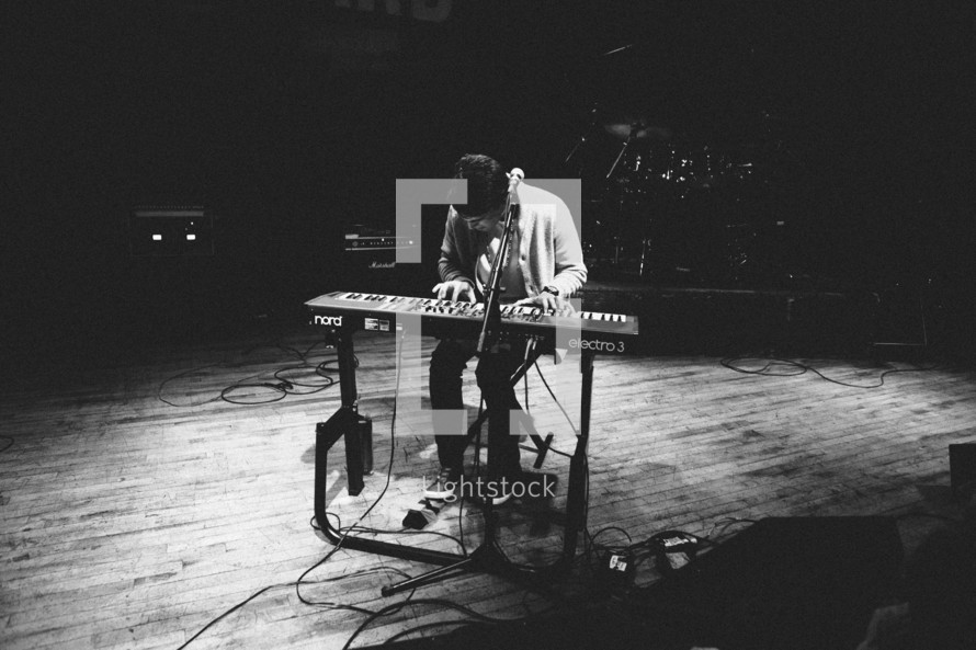 man playing a keyboard on stage
