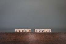 Wooden tiles spelling "Bible Study" on wooden table