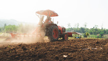 Farmers working a tractor in a field
