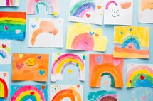 Colorful children's drawings of rainbows adorn the wall