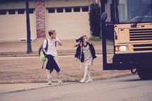 children getting off of a school bus after school 
