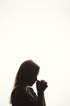 silhouette of a woman in prayer