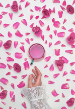 Conceptual Woman Hand, Tea With Roses and Petals