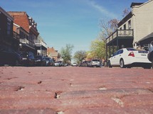 cars parked on a cobblestone street