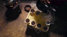 Aerial view of woman pouring coffee into cups during an Ethiopian coffee ceremony