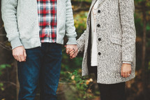 a couple in sweaters holding hands 