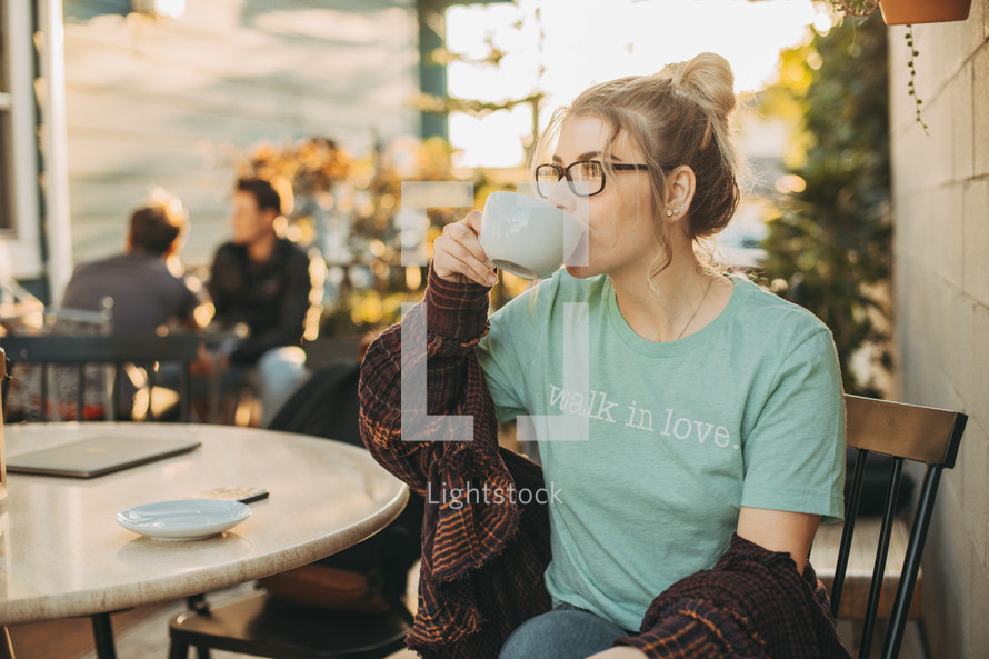 a woman at a coffee shop drinking coffee 