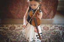 a girl child practicing her violin 