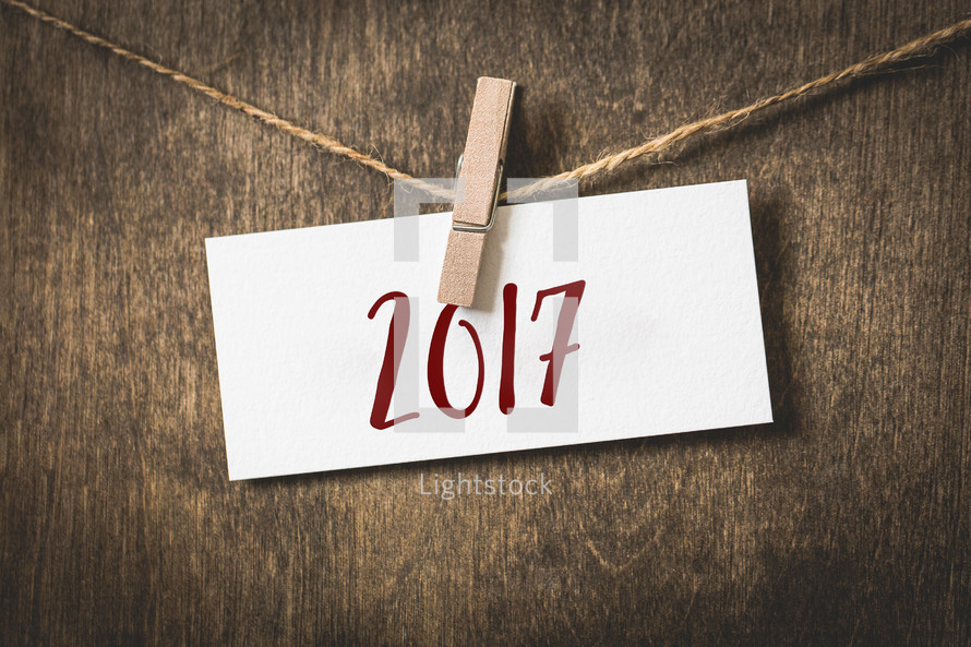 year 2017 on white card stock hanging from a clothespin on a clothesline 