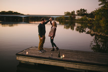 a couple dancing on a dock 
