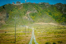 dirt road leading to home at the top of a steep hill 