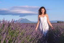 woman walking through a field of lavender 