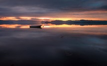 empty boat on still water at sunset 