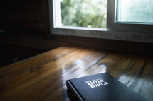 Bible on a table in sunlight from window