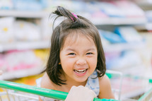 little girl in a shopping cart 