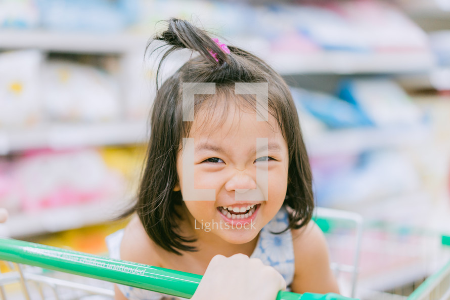 little girl in a shopping cart 
