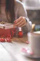 a woman wrapping a Christmas gift 