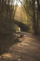 stone bridge over a stream in a forest 