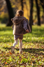a child running in fall leaves 