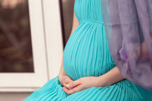 Pregnant woman on the window sill praying
