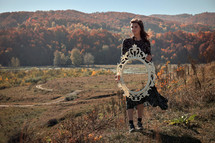 Conceptual Young Woman Holding A Mirror in Nature