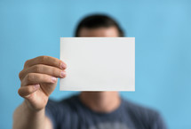 a man holding up a blank piece of paper