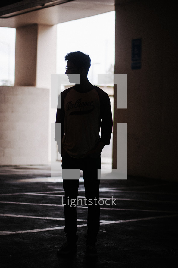 silhouette of a man in a parking garage 