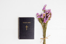 Holy Bible and dried flowers on a white background 
