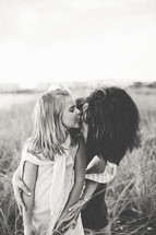 a girl kissing her mother on the cheek 