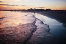 tide washing onto a shore at sunset 
