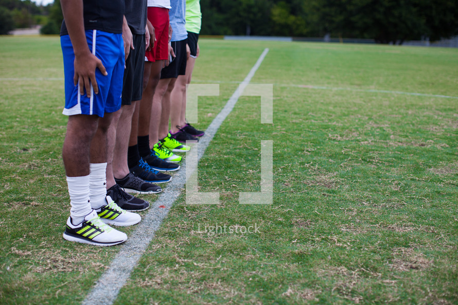 athletes standing in a row on a sports field 