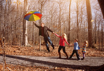 A family lifting off the ground holding an umbrella 