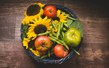 basket of tomatoes, green beans, and sunflowers 