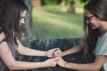 teen girls holding hands in prayer 